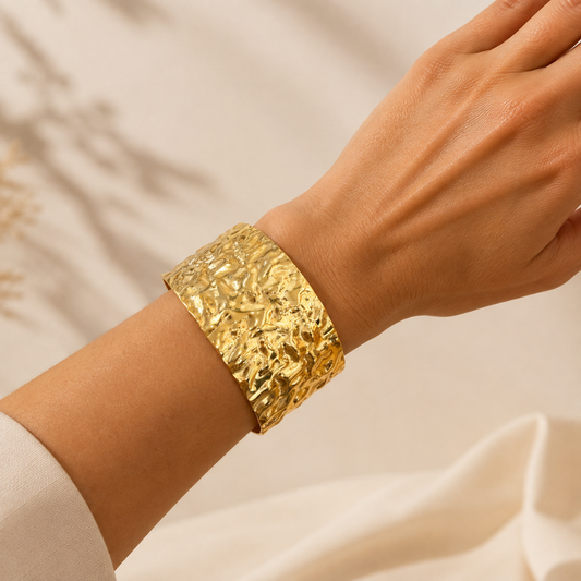 Brazalete ancho de acero dorado con textura ondulada