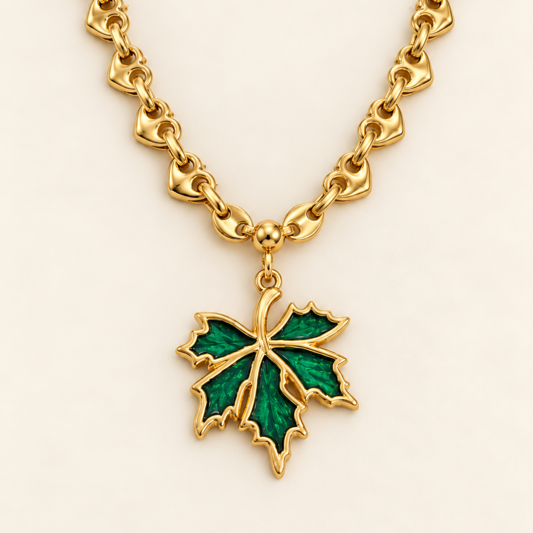 Collar Savia dorado con hoja verde y cadena de calabrote en forma de corazón.