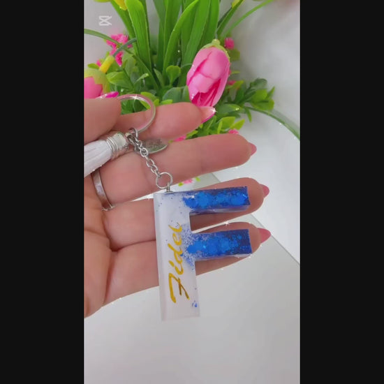Vídeo mostrando el proceso y resultado de llaveros personalizados en resina, hechos a mano, con purpurina y nombre personalizado. Un detalle original ideal para regalo, disponible en tienda física y en la web de Sfinge Joyas.