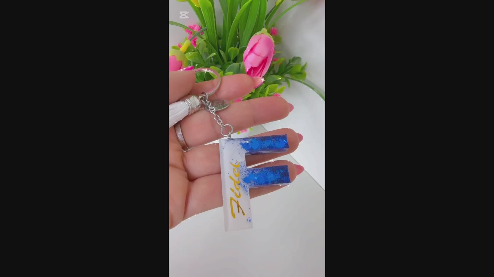 Vídeo mostrando el proceso y resultado de llaveros personalizados en resina, hechos a mano, con purpurina y nombre personalizado. Un detalle original ideal para regalo, disponible en tienda física y en la web de Sfinge Joyas.